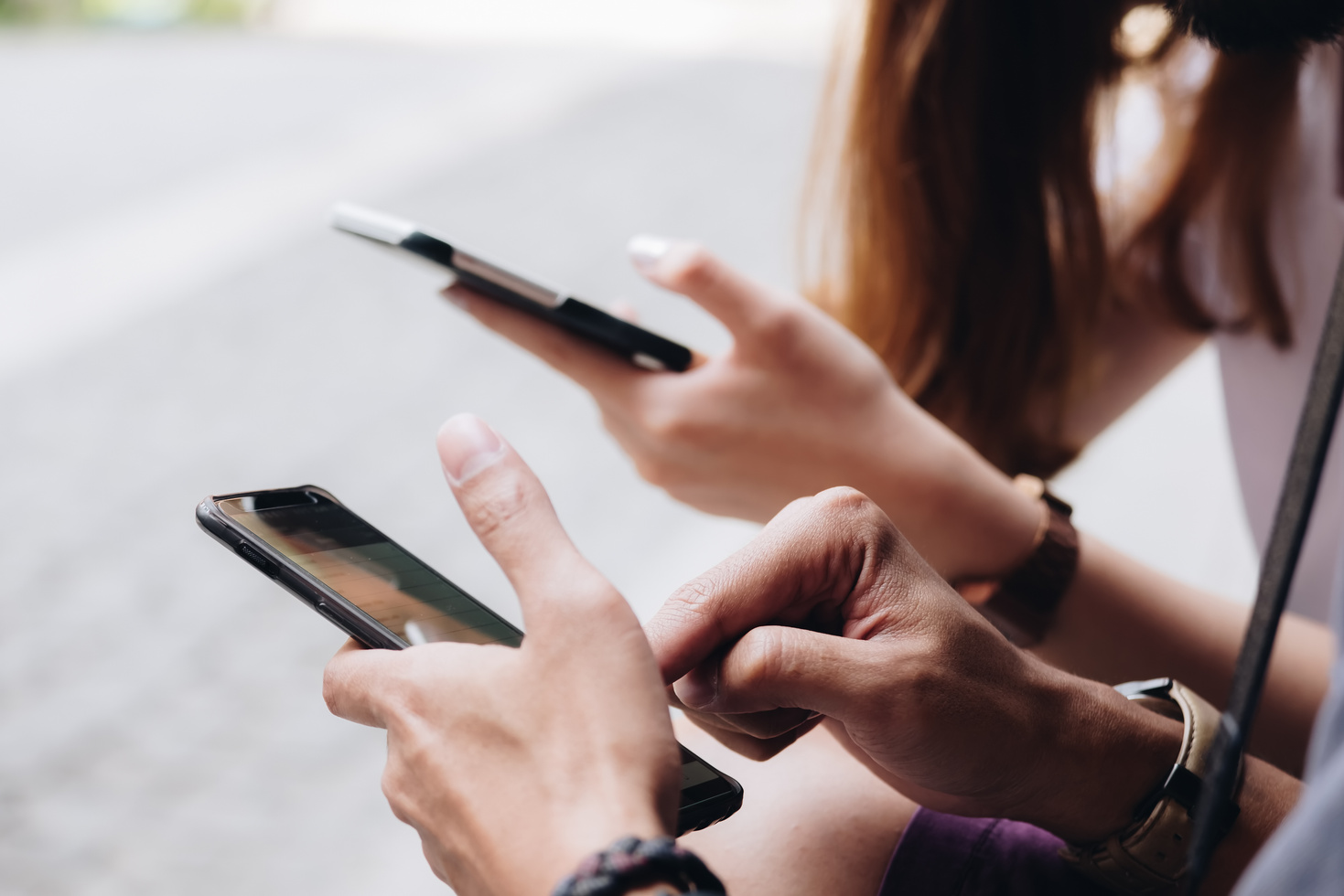 Friends Sitting in the Park Using Hands Modern Smartphone